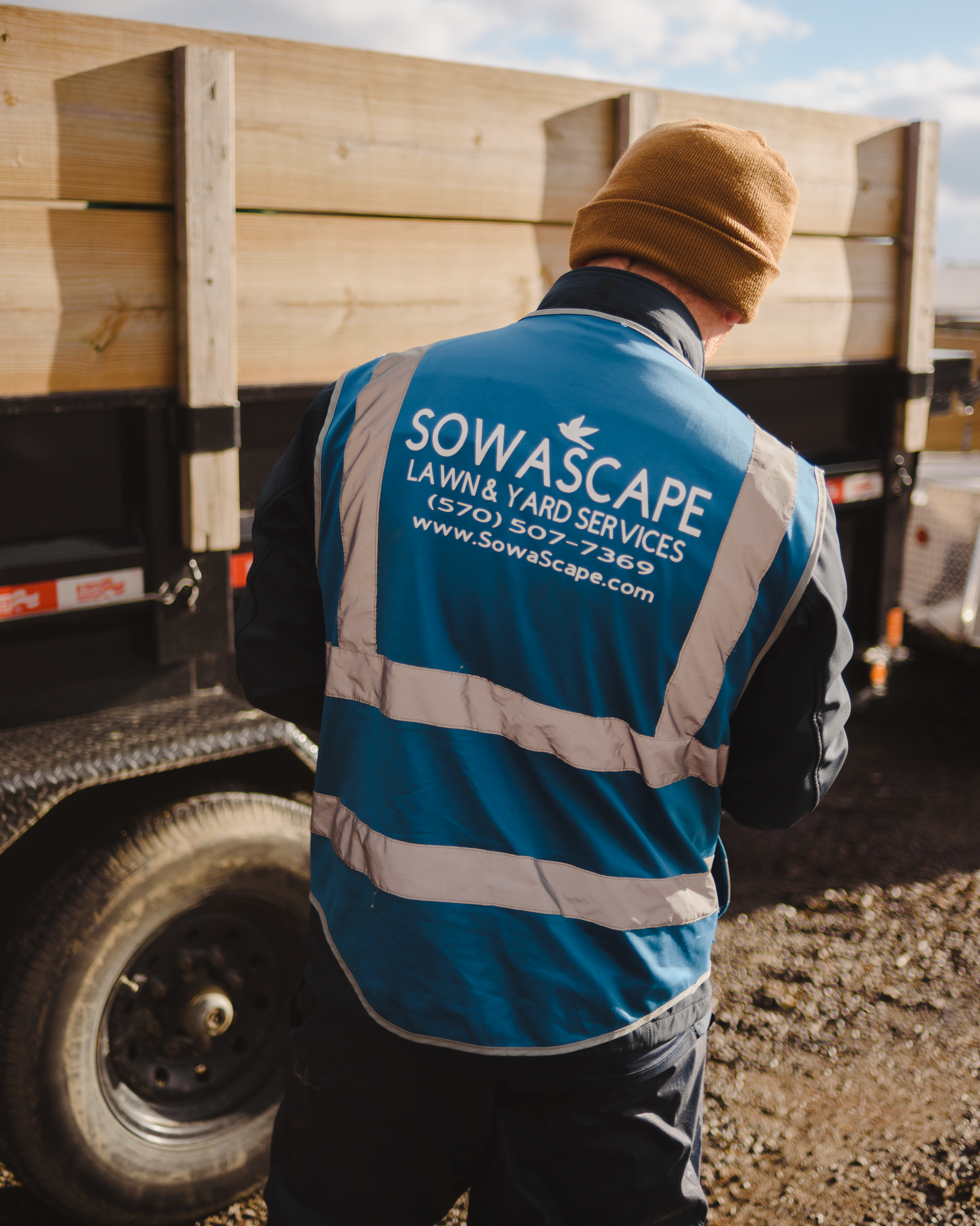 SowaScape crew member in branded hi-vis at equipment trailer